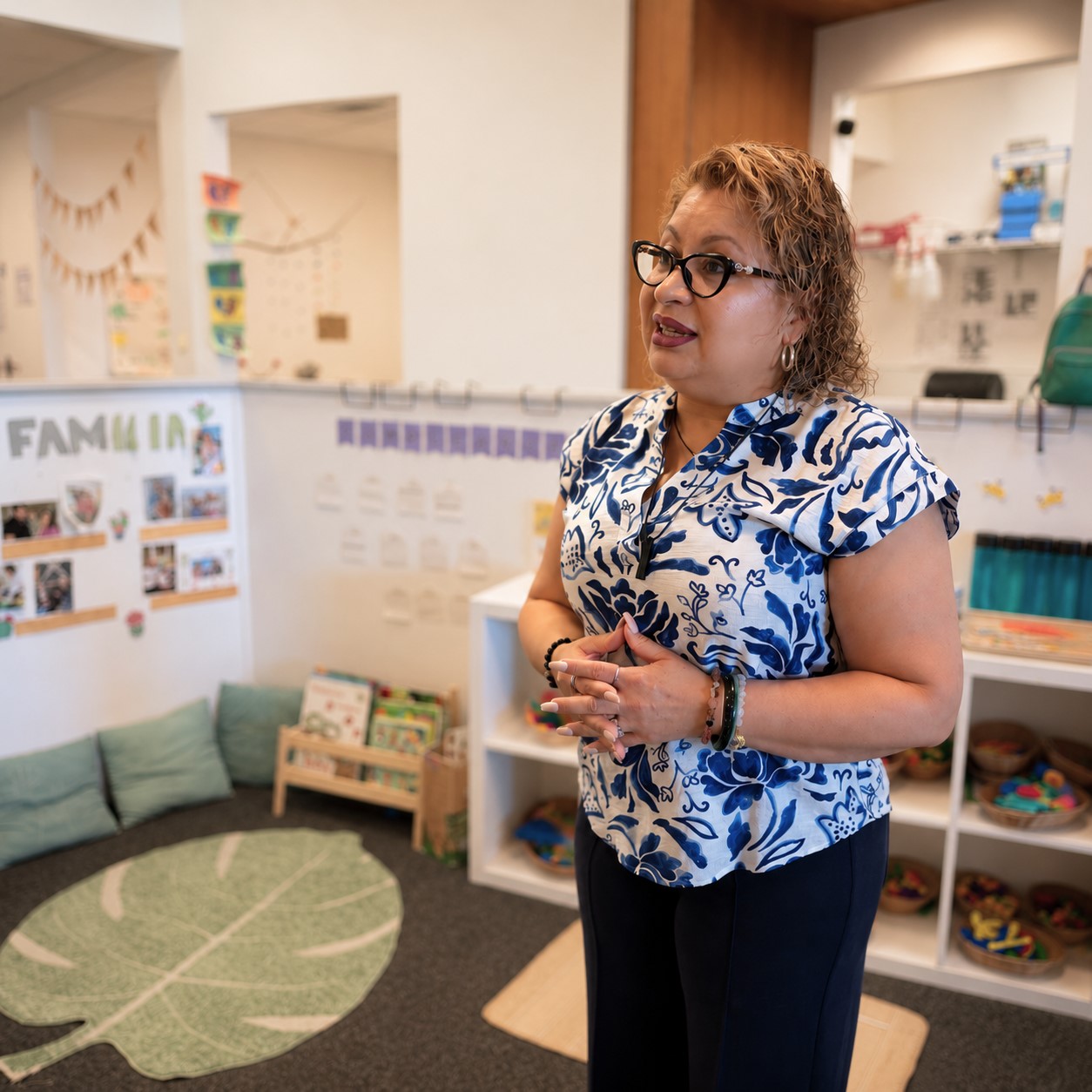 Staff member standing in a classroom at Edina Daycare, surrounded by organized learning materials and child-centered spaces.